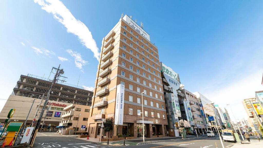 和光市Toyoko Inn Wako-shi Ekimae的一条城市街道拐角处的高楼