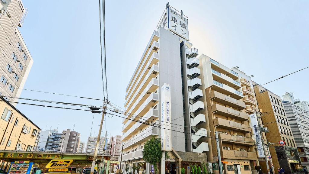 大阪Toyoko Inn Shin-Osaka Chuo-guchi Honkan的一座高大的建筑,上面有钟
