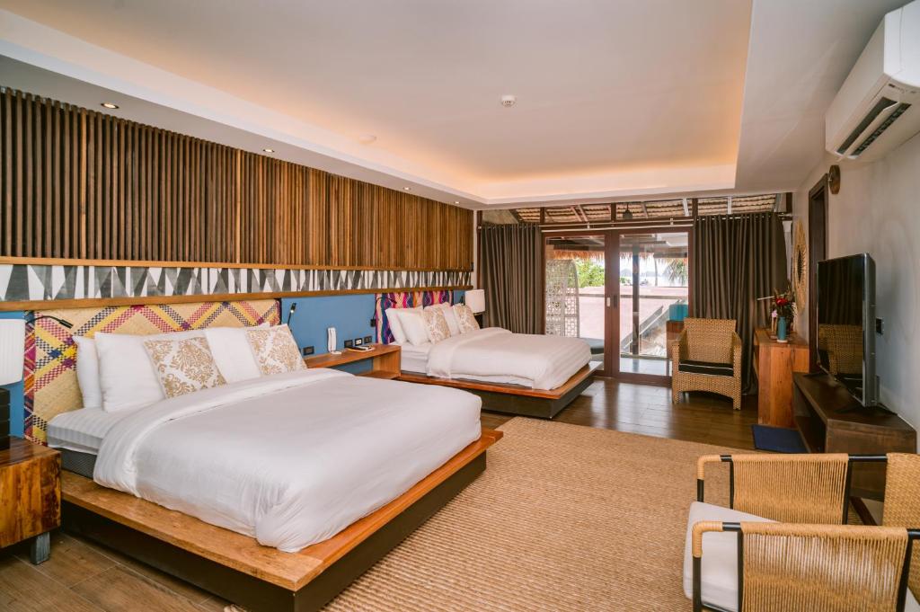 爱妮岛Banig Beach Resort El Nido的一间带两张床的卧室和一间客厅