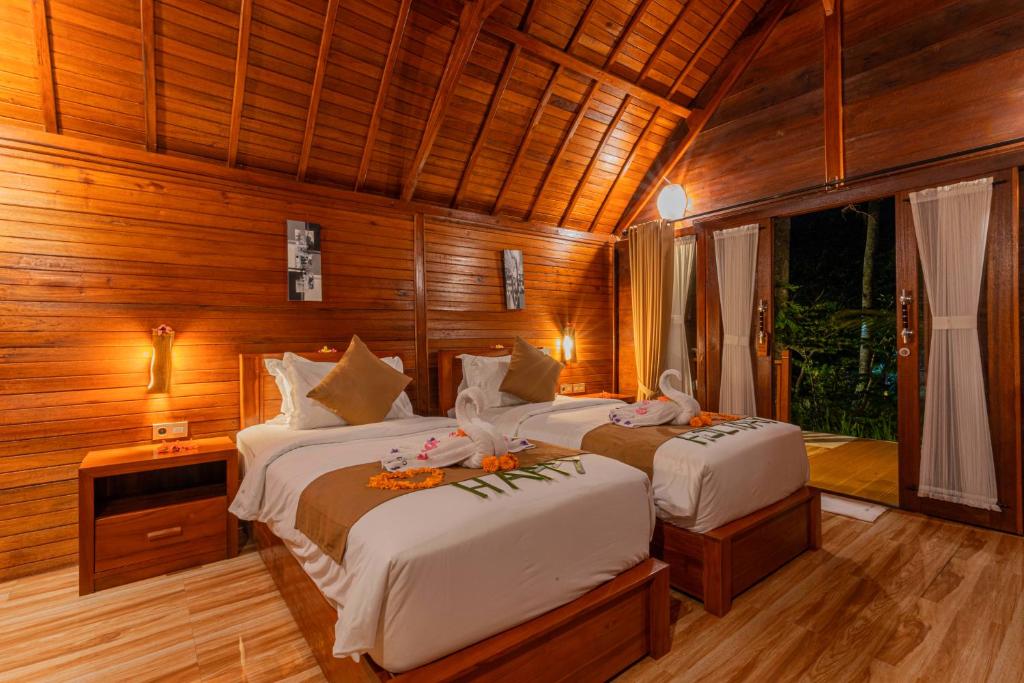 珀尼达岛Bila Penida Resort & Farm的木墙客房的两张床