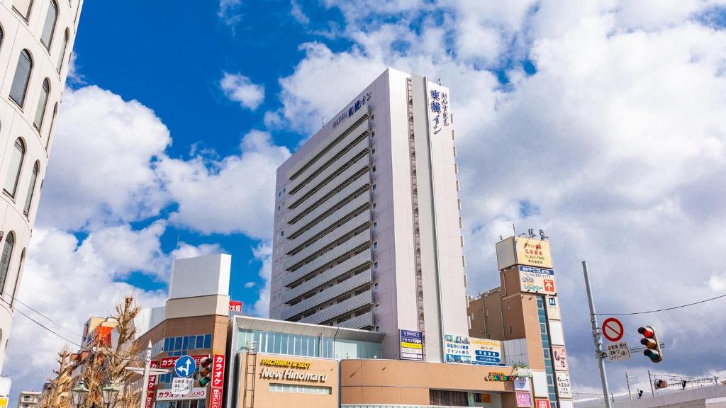 新泻Toyoko Inn Niigata Ekimae的一条城市街道上高大的白色建筑
