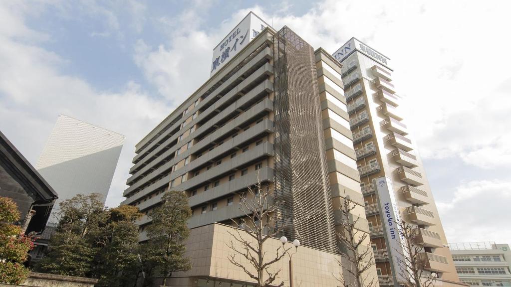 宇都宫Toyoko Inn Utsunomiya Ekimae No 1的一座高大的建筑,旁边有一个标志