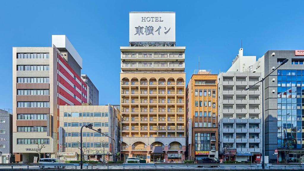 大阪Toyoko Inn Osaka Namba Nishi的一座高大的建筑,上面有标志