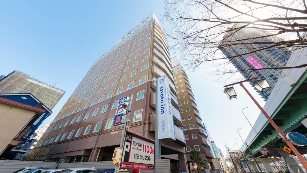 名古屋Toyoko Inn Nagoya Meieki Minami的一座高大的建筑,旁边有一个标志