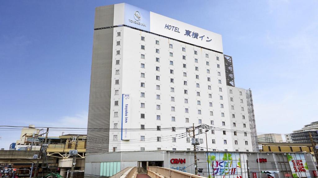 东京Toyoko Inn Tokyo Shinagawa Aomono-yokocho-eki的白色的建筑,上面有标志