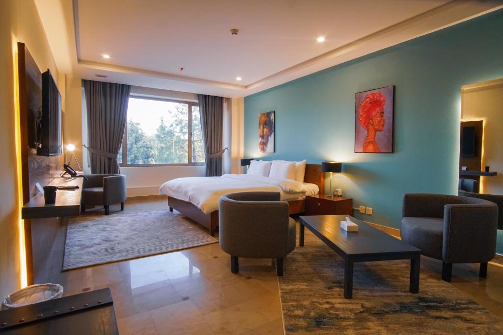 伊斯兰堡Roomy Signature Hotel, Islamabad的酒店客房带一张床、一张桌子和椅子