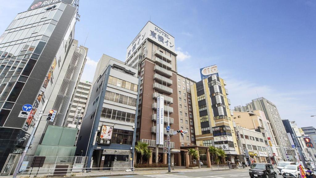 福冈Toyoko Inn Hakata Nishi-nakasu的一座有高楼和有车的街道的城市