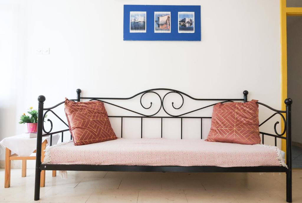 杜布罗夫尼克HI Hostel Dubrovnik的一张黑色长凳,上面有两个粉红色的枕头