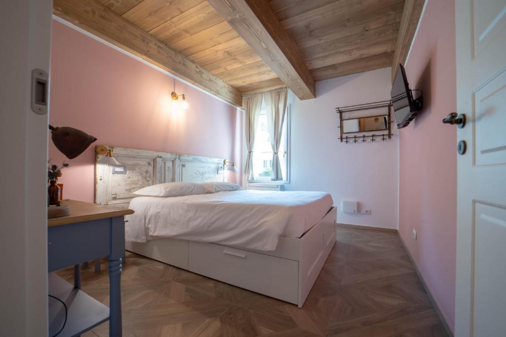 拉文纳Le Camere di Olivia的卧室配有一张白色大床和一张书桌