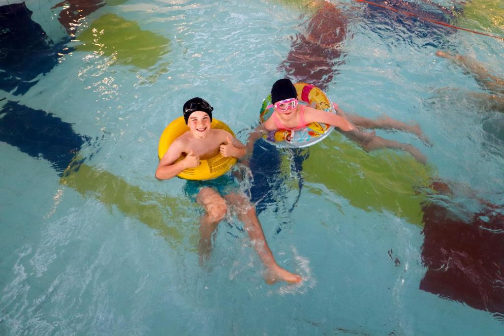 纳斯鱼鹰酒店 的两人在带飞盘的游泳池游泳