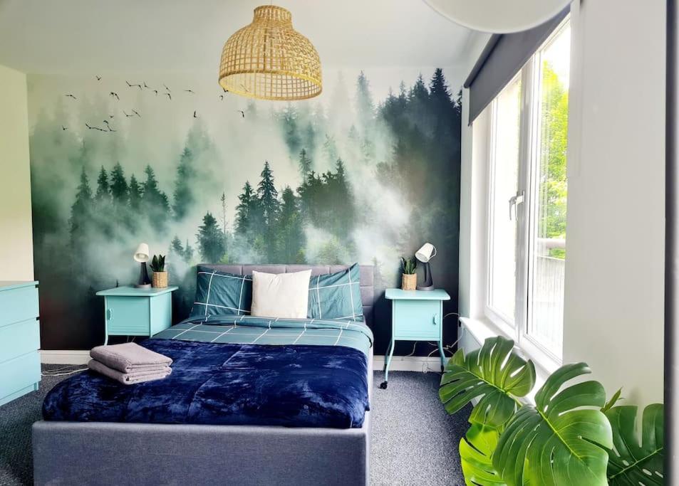 格拉斯哥Spacious 5bed house, FREE parking, NO PARTY !的卧室配有一张壁挂森林壁画的床