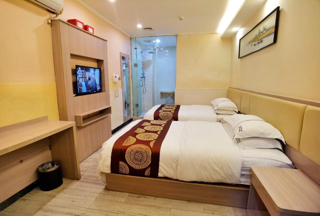 深圳松缘酒店的酒店客房,配有床和电视