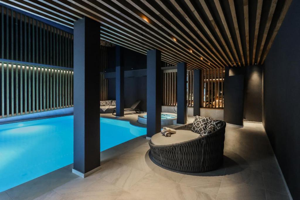 纳兹-夏韦斯Hotel Waldheim的一间设有游泳池和浴缸旁长凳的客房