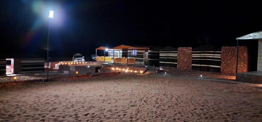 瓦迪拉姆Wadi Rum Quiet Sky的夜间海滩,有街灯
