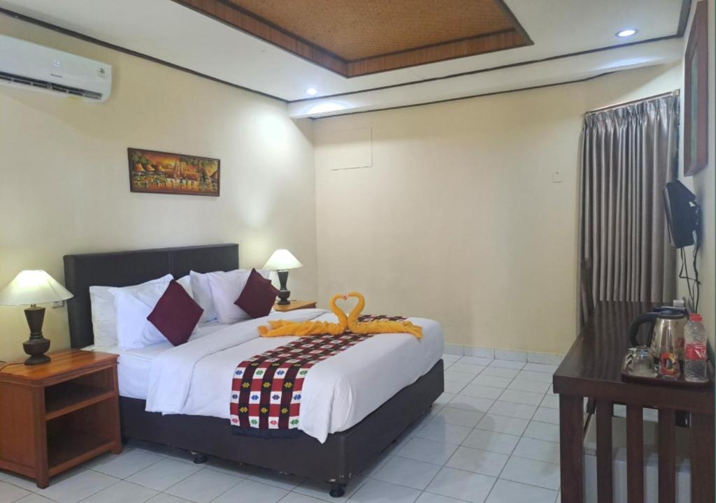 罗威那罗威那海滩酒店的一间卧室配有一张带白色床单的大床