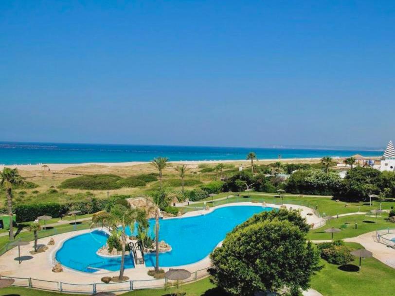 萨阿拉德洛斯阿图内斯Apartasuites Royal Zahara, Máximo confort con vistas al mar的享有度假村游泳池的空中景致