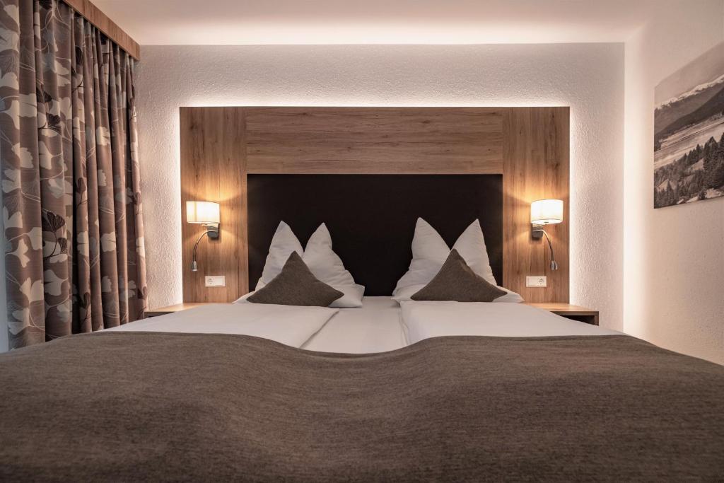 普雷瑟格尔塞阿尔盆亚德里亚酒店 的卧室配有一张带白色床单和枕头的大床。