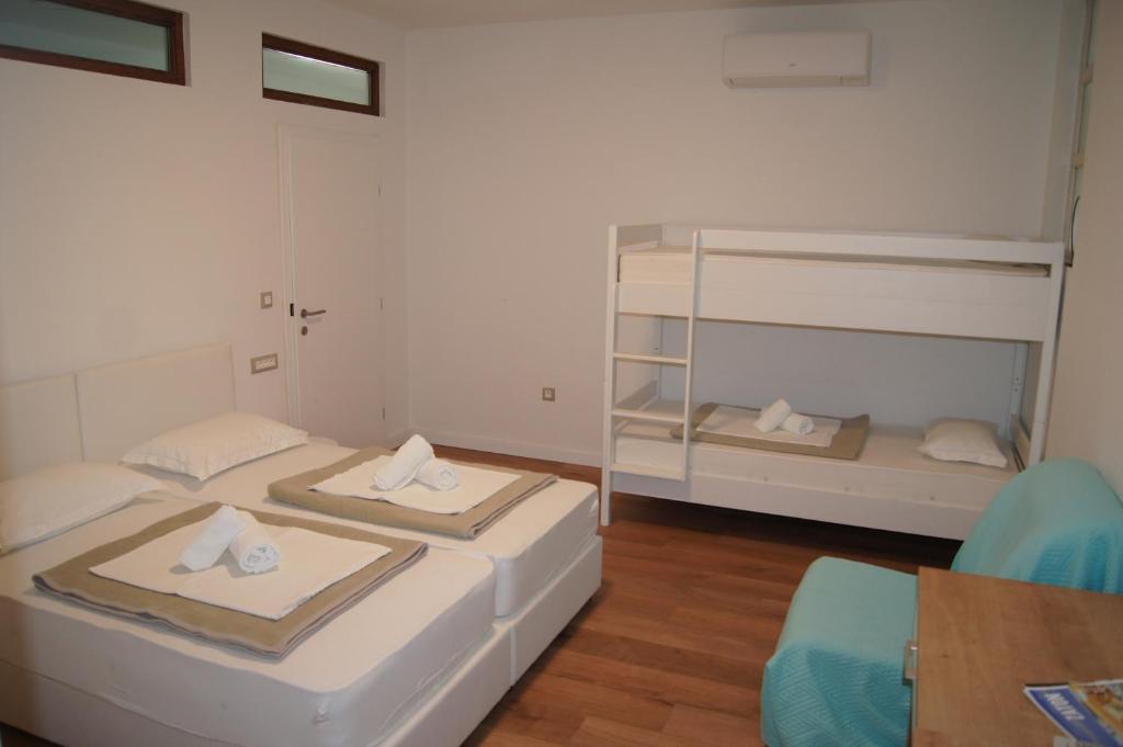 扎达尔Hostel Stadion - Zadar的配有一张桌子和一把椅子的客房内的两张床