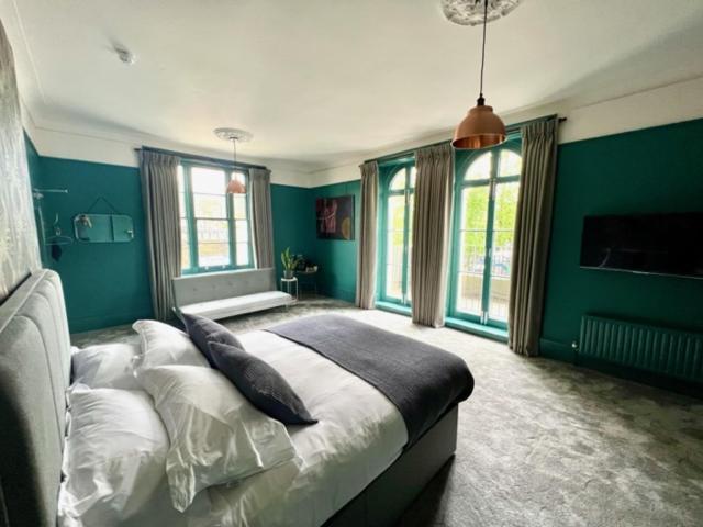 伦敦The Crown Rooms的一间卧室设有绿色的墙壁和一张带枕头的床