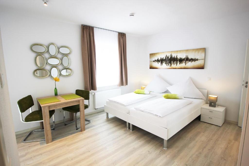 班贝格花园城市公寓式酒店的白色卧室配有床和书桌