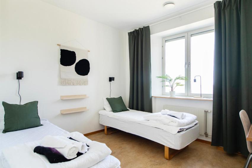哈诺桑德Härnösands folkhögskolas Bed & Breakfast的一间卧室设有两张床和窗户。