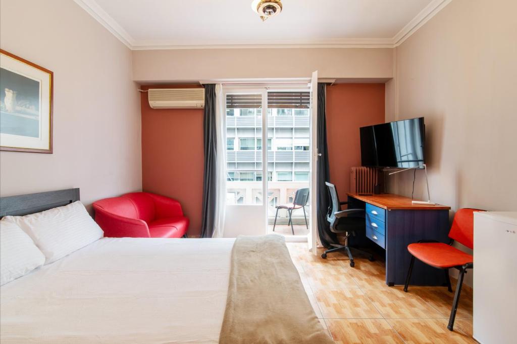 雅典Charlie city center room的一间卧室配有一张床、一张书桌和一台电视。