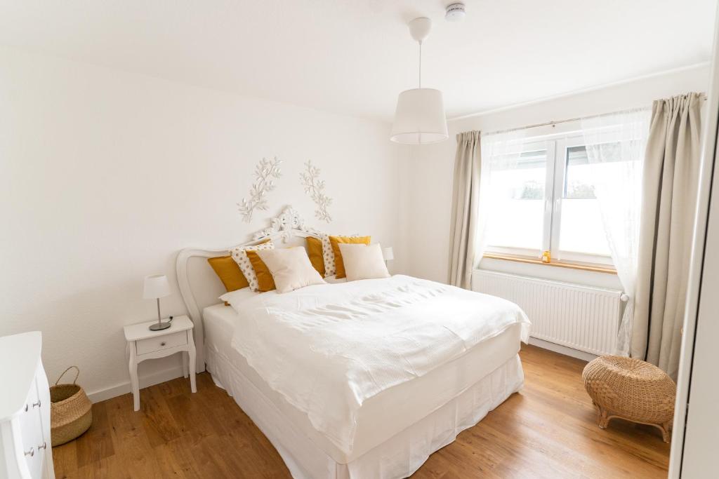 策勒Ferienwohnung Gartenkamp Celle的白色的卧室设有白色的床和窗户。