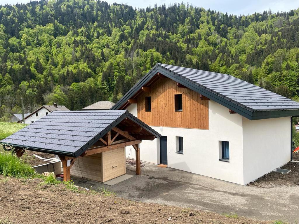 贝勒沃Luxurious new villa in the Alpes with sauna and jacuzzi的屋顶上有一个太阳能屋顶的房子