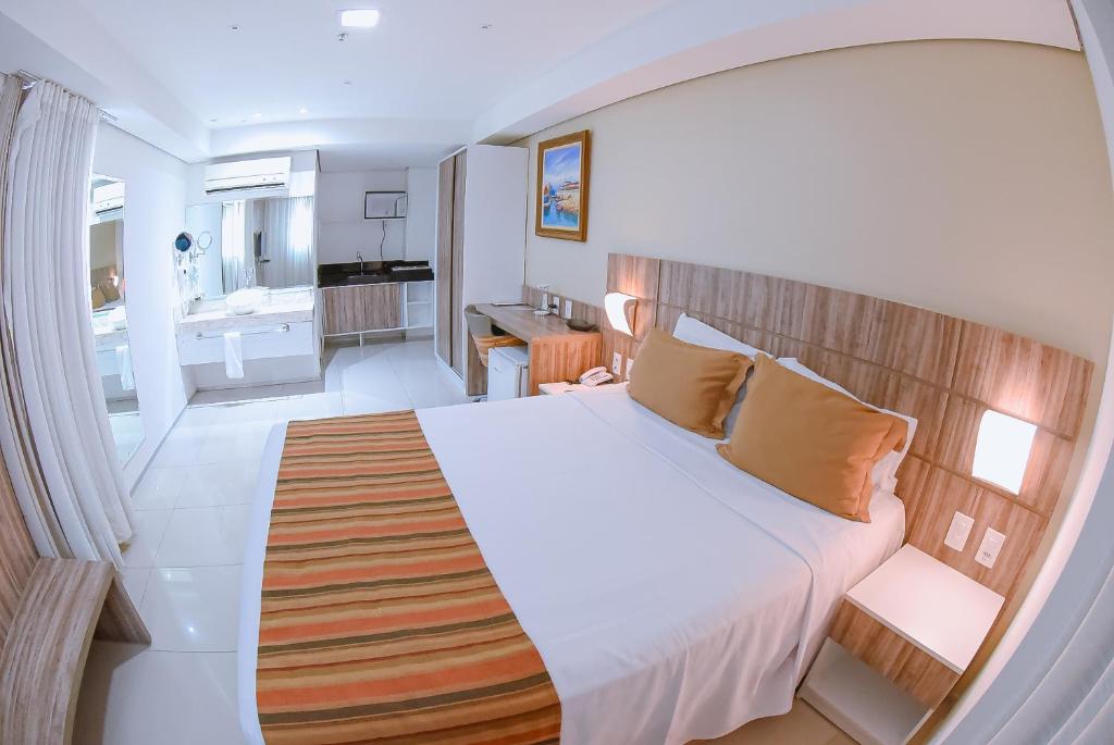 圣路易斯Profissionalle Hotel São Luís的一间带大床的卧室和一间浴室