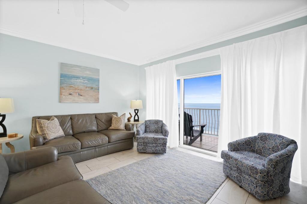 巴拿马城海滩Coral Reef Resort by Panhandle Getaways的客厅配有沙发和两把椅子