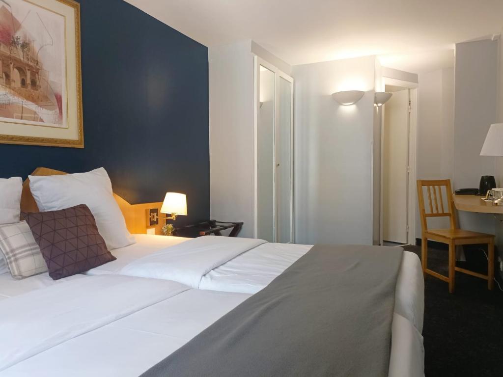 巴黎格兰德杜卡尔瓦多斯酒店的卧室配有一张白色的大床和一张桌子