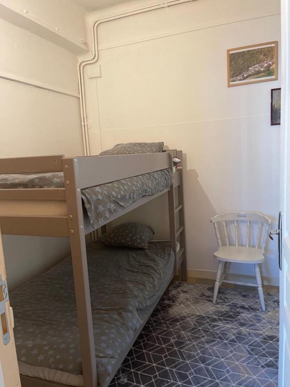 维特里勒弗朗索瓦Chez Léandre的一间卧室配有两张双层床和椅子