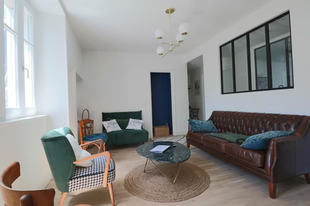拉布尔布勒Le Gentiane - Villa Chanterive的客厅配有棕色真皮沙发和椅子