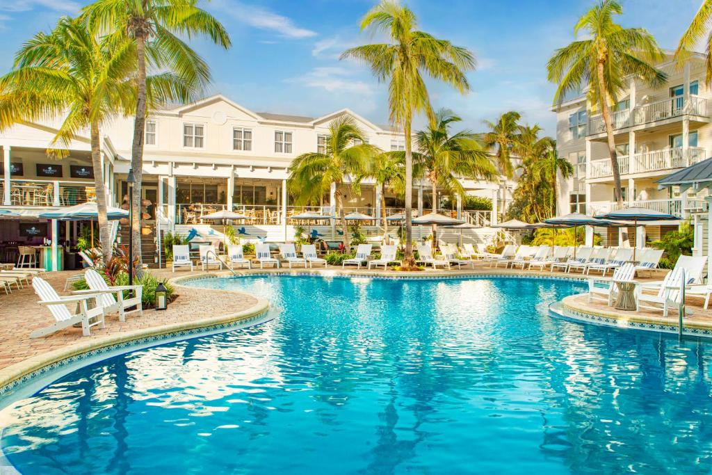 基韦斯特Margaritaville Beach House Key West的度假村内带椅子和棕榈树的游泳池