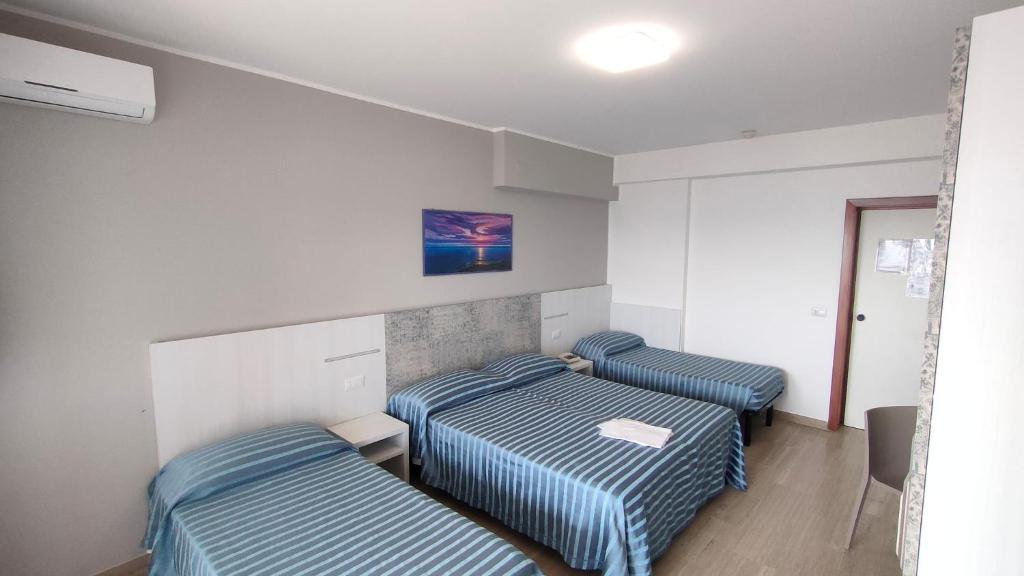 马帝斯兹罗加尔夫酒店的配有蓝色条纹床单的客房内的两张床