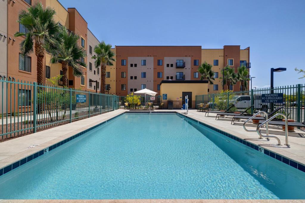 凤凰城WaterWalk Phoenix - North Happy Valley的棕榈树和建筑公寓大楼的游泳池