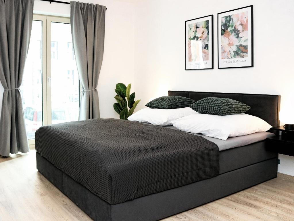 布伦瑞克LIGHTPLACE • Design • Boxspring • Balkon • 2 Smart TV •Innenstadt的一间卧室设有一张黑色的床和一个窗户。