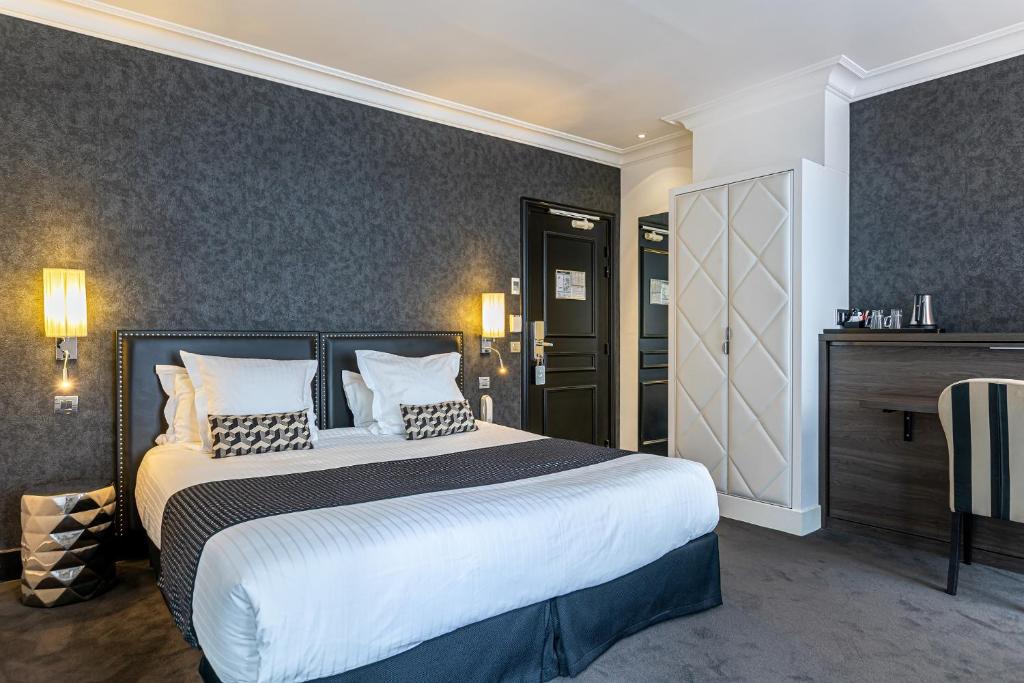 巴黎迪瓦歌剧院酒店的卧室配有一张带白色床单和枕头的大床。