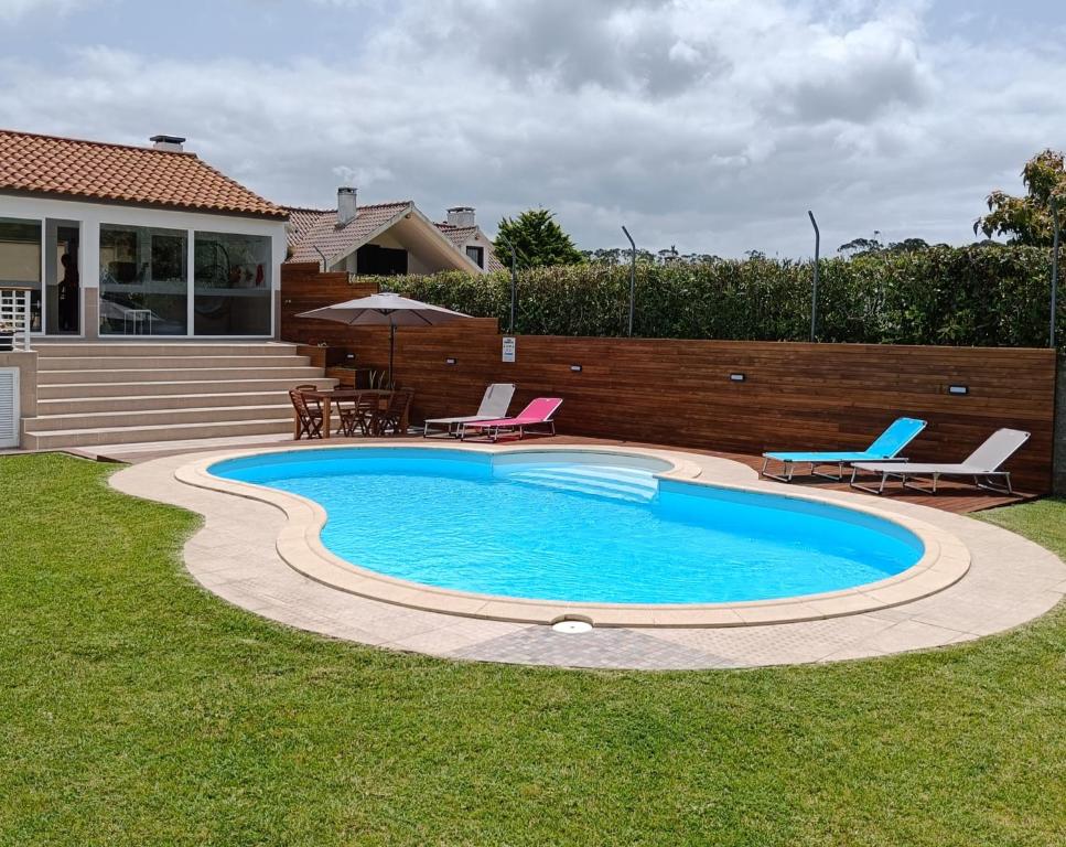 蓬塔德尔加达CASA XAVIER - PISCINA 2735/AL的庭院内的游泳池,配有椅子和桌子