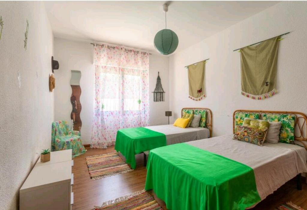 坎佩略CMHOPE Green Room的一间卧室配有两张带绿床单的床