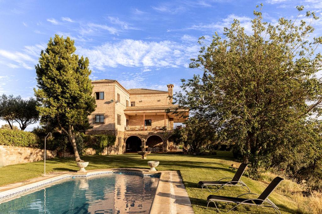 托莱多CASA RURAL Cigarral del Pintor的一座大房子,在庭院里设有一个游泳池