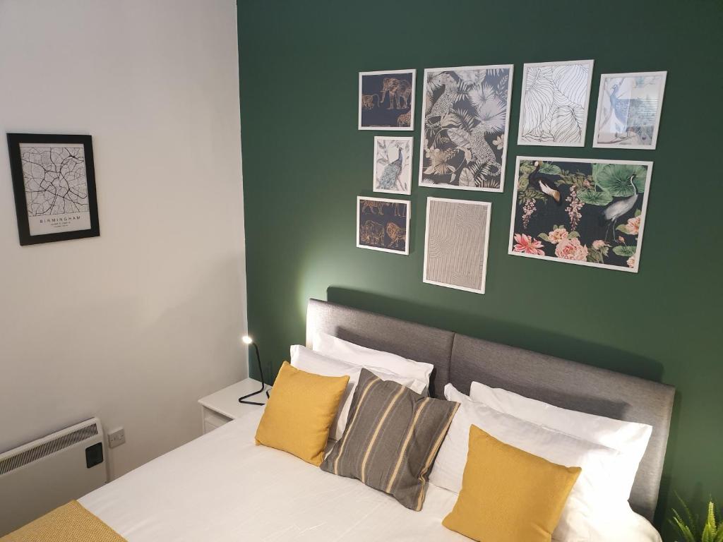 伯明翰Platinum Apartment Birmingham- Free Secure Parking- Fast Fibre Wi-Fi的一间卧室设有绿色的墙壁和一张带枕头的床