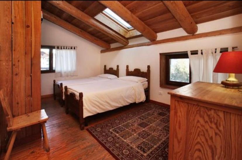 萨奥兹-杜尔克斯Hotel Derby Bar的一间带一张床的卧室,位于带木制天花板的房间内