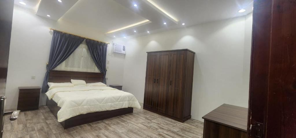 Ahad Rafidahوحدات جنان的一间卧室配有一张大床和一个木制橱柜