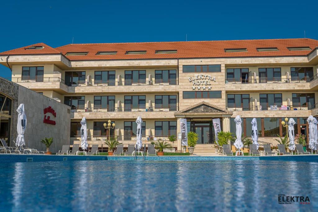 旧瓦马Elektra Vama Veche的前面有一个游泳池的酒店
