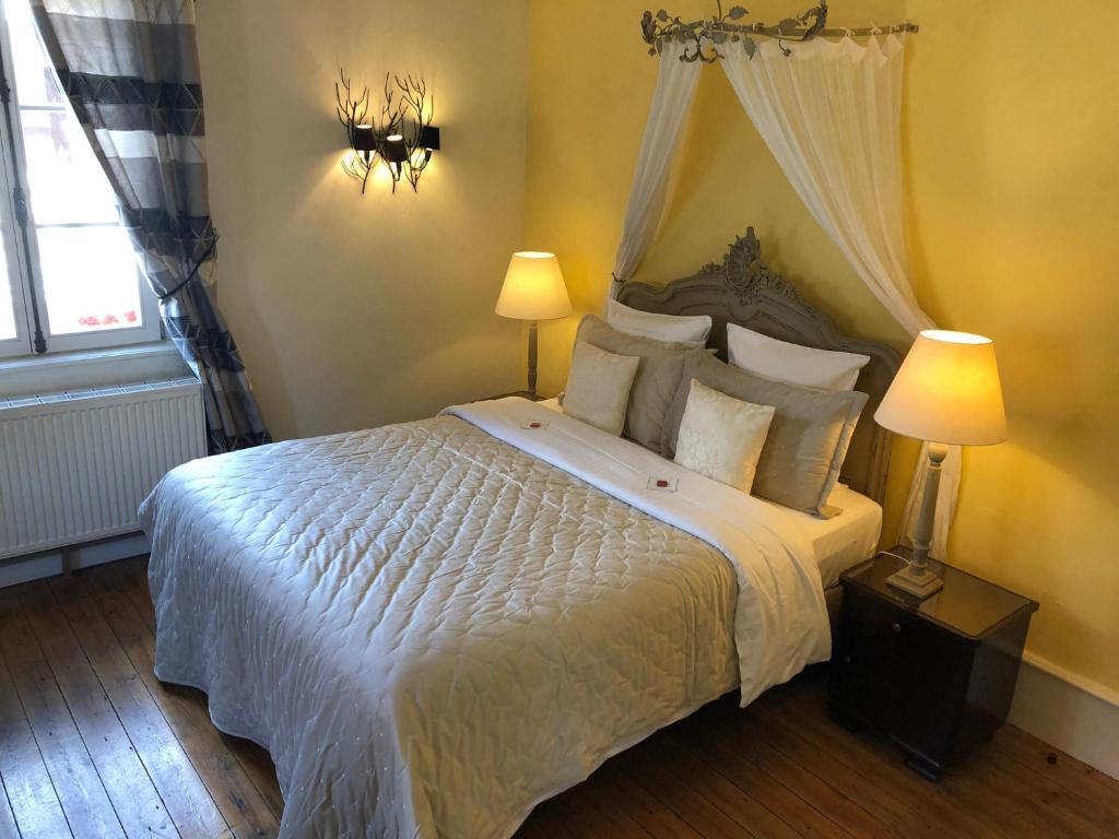 伊费茨海姆船舶魅力酒店的一间卧室配有一张带两盏灯的大型白色床。