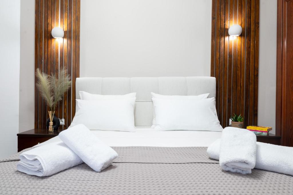 卡瓦拉Seaside Guesthouse的卧室配有白色床和毛巾