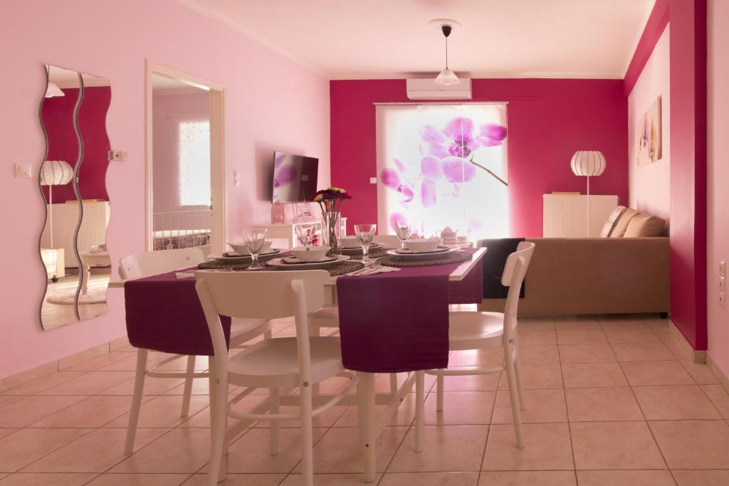 普雷韦扎Flower Pot Complex Aparts!的一间拥有紫色墙壁和桌椅的用餐室