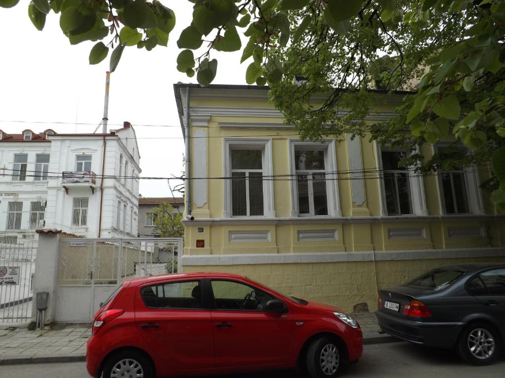 瓦尔纳雷斯卡亚巴卡旅馆的停在黄色建筑前面的红色汽车