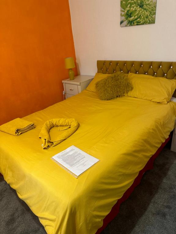 克劳利Quick Stop Night Stay - Gatwick的一张黄色床单的床和一部电话